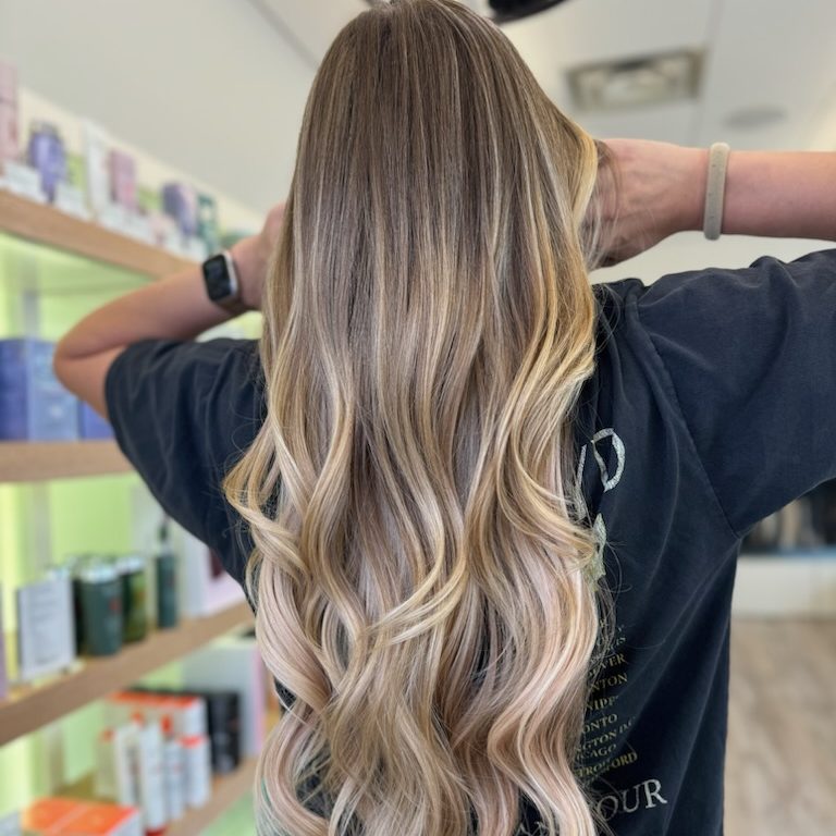 image1 Long blonde hair with extensions shown from the rear. Low-maintenance blonde balayage.