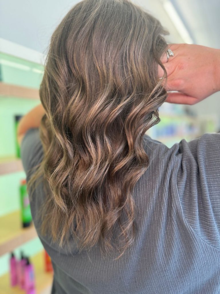Long blonde hair shown from the rear. Sun-kissed balayage