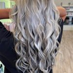 A blonde woman showing her hair from behind with Bombshell Luxe Extensions installed.
