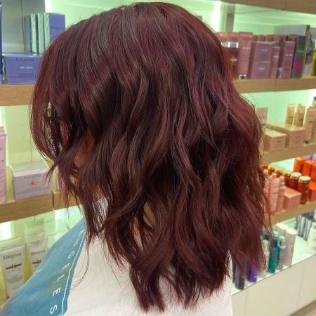 woman with shoulder-length hair after getting an all-over color service.