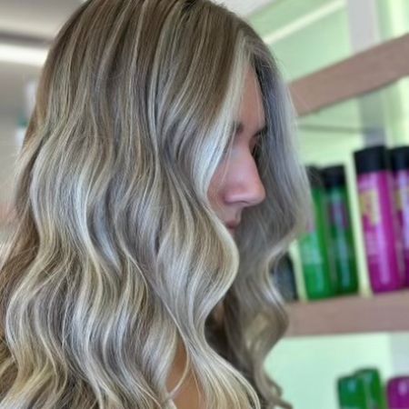 Blonde woman with long wavy hair. Dimensional balayage.