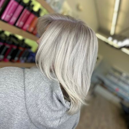 Woman showing a side profile of her hair after a Blonding treatment was done.
