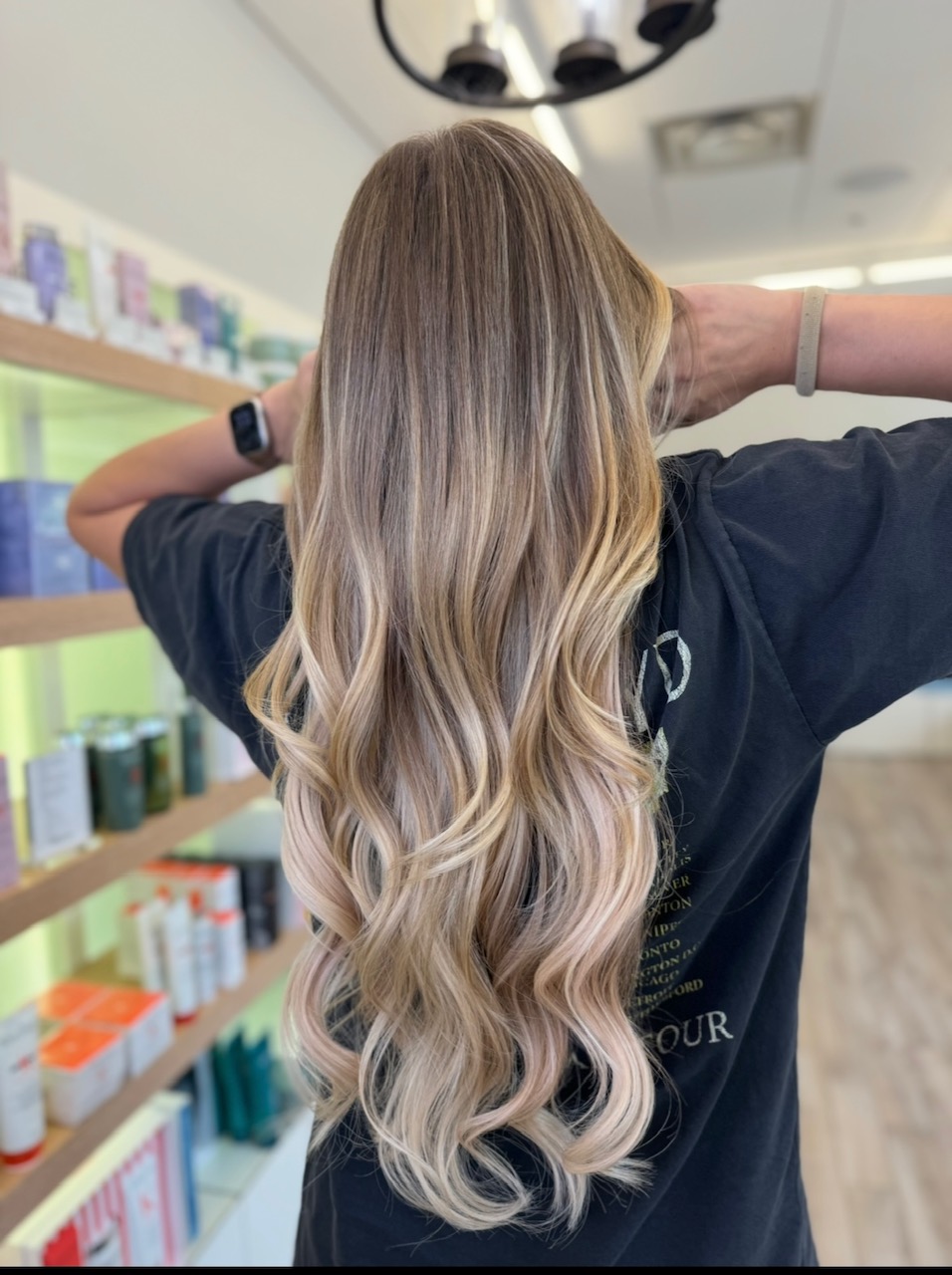 Long blonde hair with extensions shown from the rear. Low-maintenance blonde balayage.